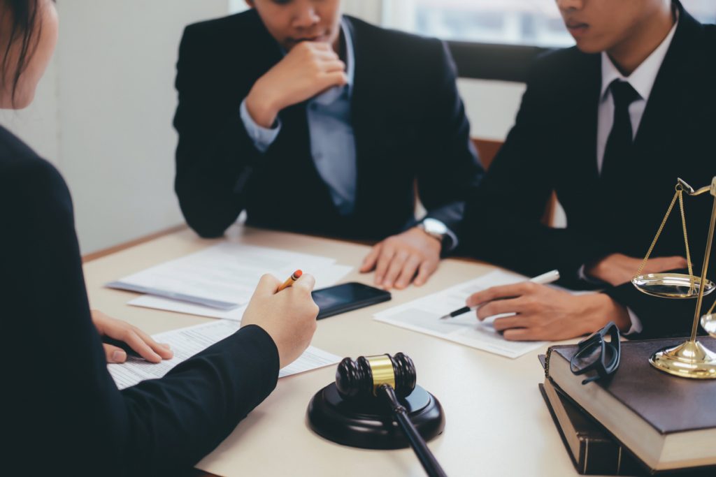 Legal team having a conversation at a table with documents